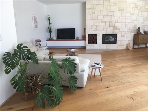 Dunsborough Beach House - Inside the house is a huge open kitchen, living dining, lounge, area with limestone wall and wood fire. The kitchen has triangular island bench. The pictures show the front of house in different seasons. Also included is a view of the street which shows that its super quiet with heaps of parking. We also have 2 different parking areas at the house which could easily accommodate 10 cars. The living open area is super light and has lots of plants and this opens out to the backyard through a wall of glass stacker doors which blends the indoor/outdoor areas. There a large white limestone curved wall in the backyard and the pool. All areas are available for filming. (18/02/2022 - Credits: Michelle Cameron-Brown)